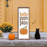 a black cat sitting next to a sign that says hello pumpkin