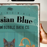 a hand holding a framed print with a vintage-style design.