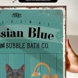 a hand holding a framed print with a vintage-style design.