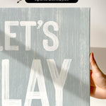 a hand holding a sign that says let&#39;s play