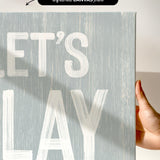 a hand holding a sign that says let&#39;s play