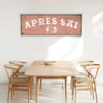 a wooden dining table with four chairs, and a framed sign above it that reads "APRés Ski".