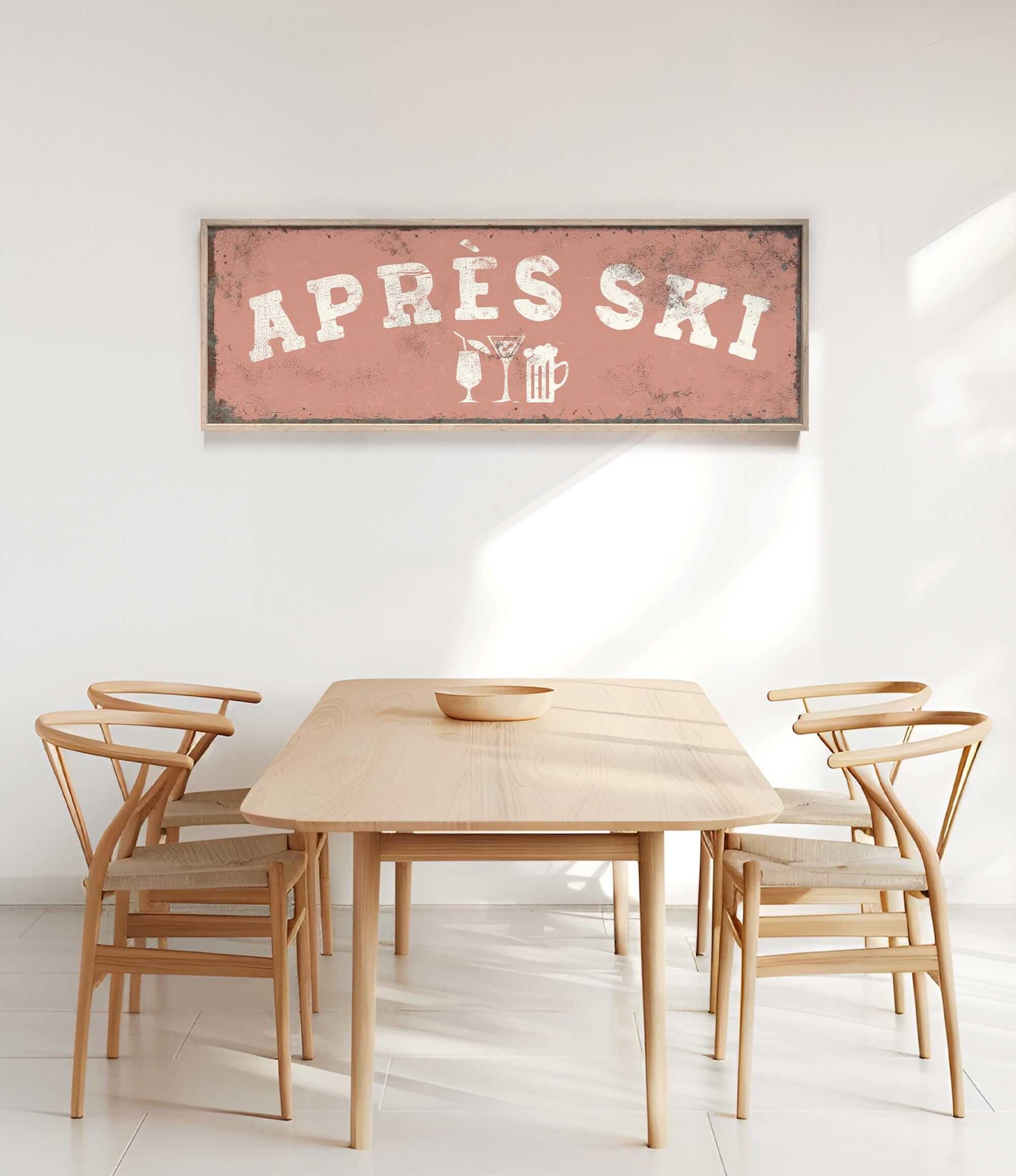 a wooden dining table with four chairs, and a framed sign above it that reads "APRés Ski".