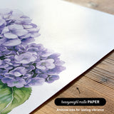 a close-up view of a piece of paper with a detailed illustration of a cluster of purple hydrangea flowers.