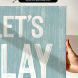 a hand holding a sign that says let&#39;s play