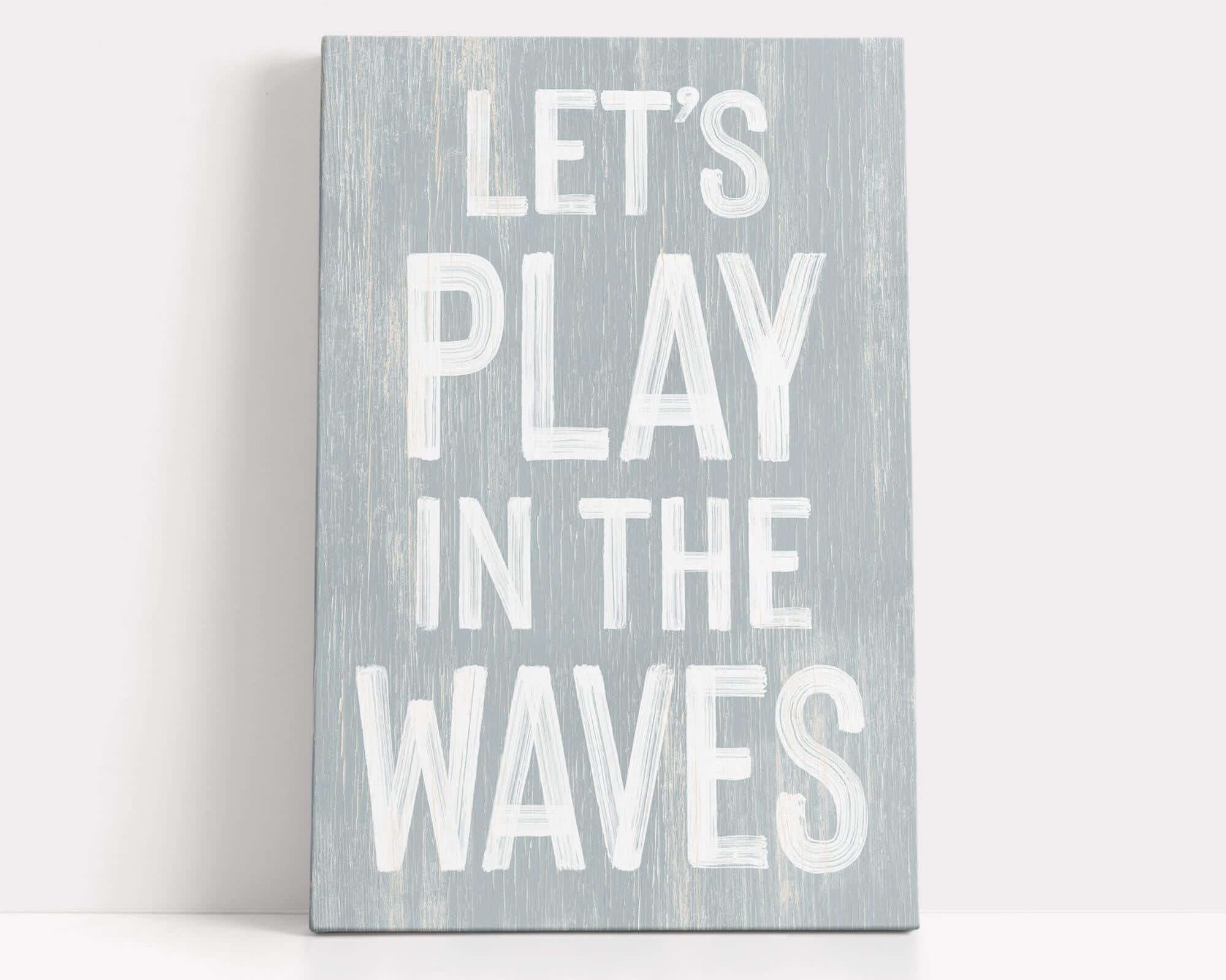 a wooden sign that says let's play in the waves