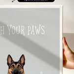 a hand holding a canvas print of a dog with the text "Witch Your Paws" written on it.