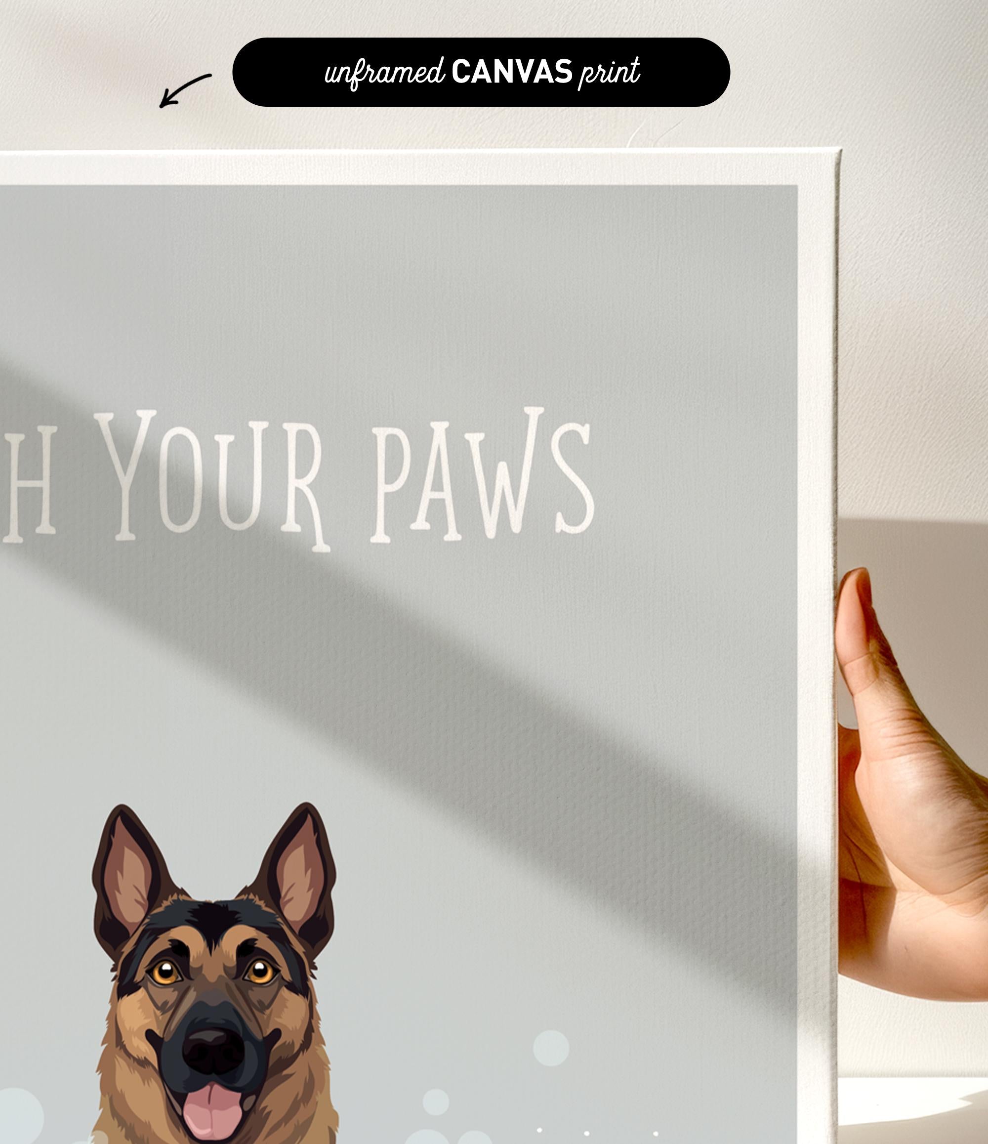 a hand holding a canvas print of a dog with the text "Witch Your Paws" written on it.