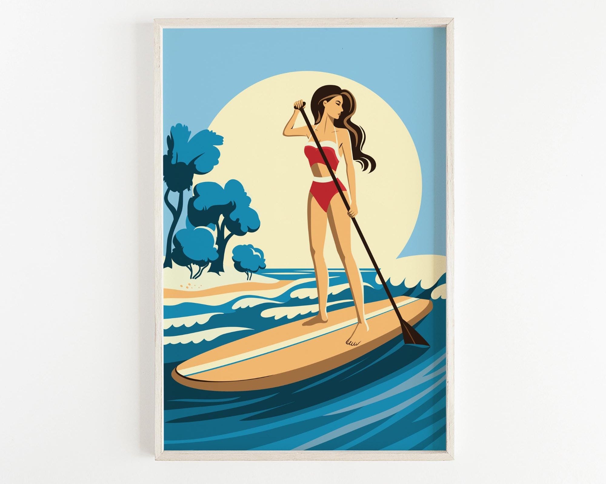 A woman in a red swimsuit is paddleboarding on a blue ocean, holding a paddle and standing on a surfboard.