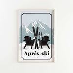 A framed print featuring a pair of black Adirondack chairs with skis crossed in front of them, set against a snowy mountain landscape.