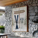 a picture of skis hanging on a stone wall