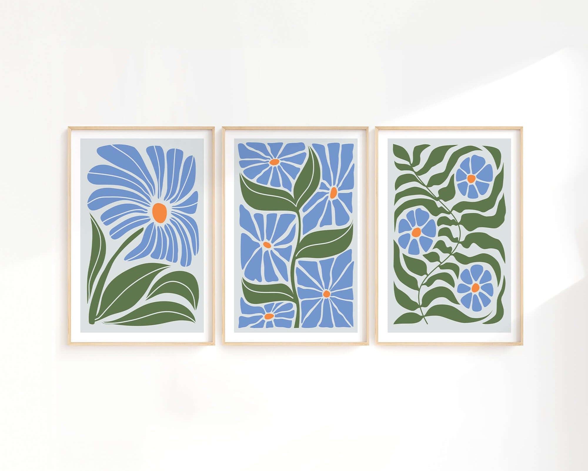 The Flower Blocks Triptych | Set of Three Prints | 011 features delicate blue flowers and green leaves, bringing a fresh, serene touch to your home decor. Perfect for displaying together, these prints add elegant style to any crisp white wall.