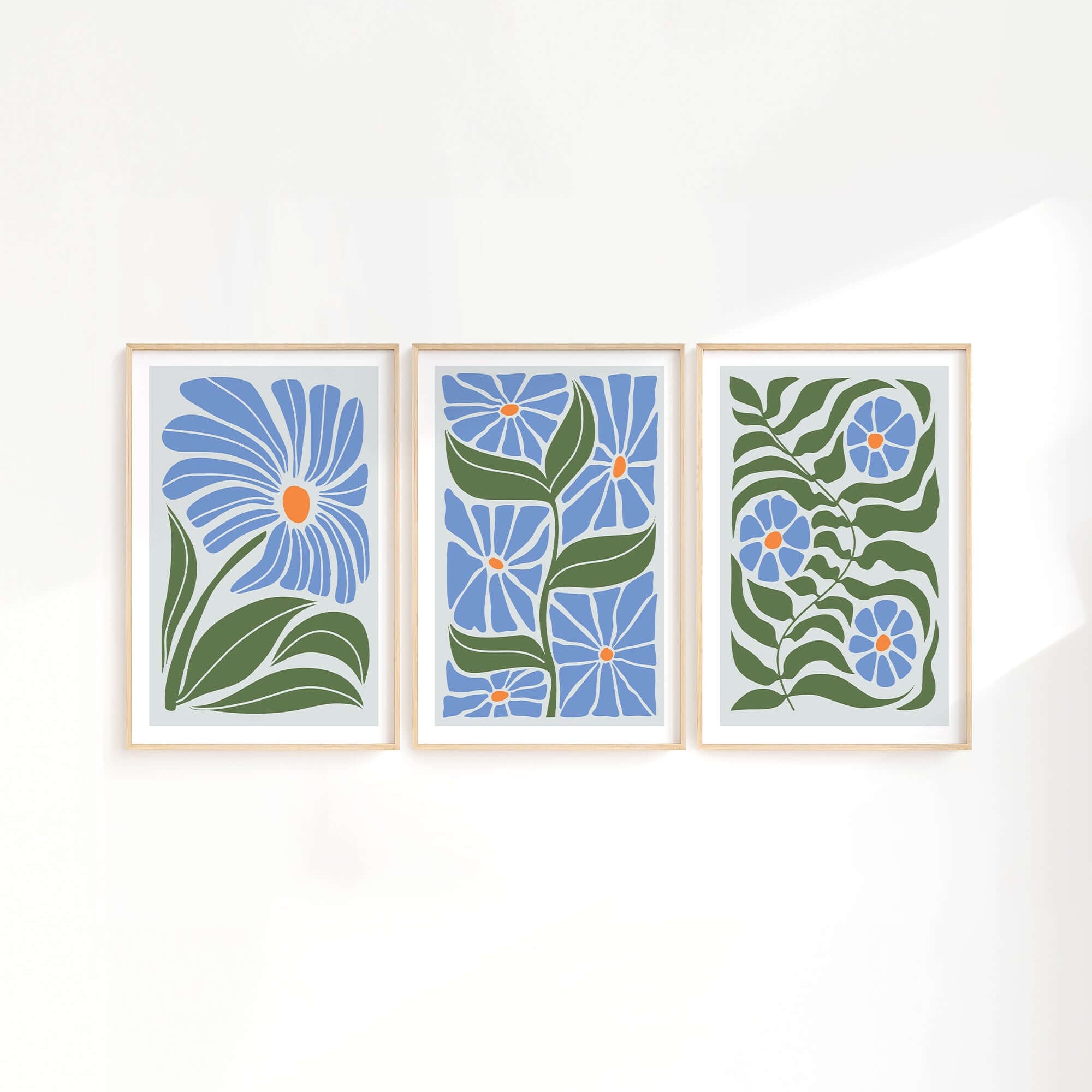 The Flower Blocks Triptych | Set of Three Prints | 011 features delicate blue flowers and green leaves, bringing a fresh, serene touch to your home decor. Perfect for displaying together, these prints add elegant style to any crisp white wall.