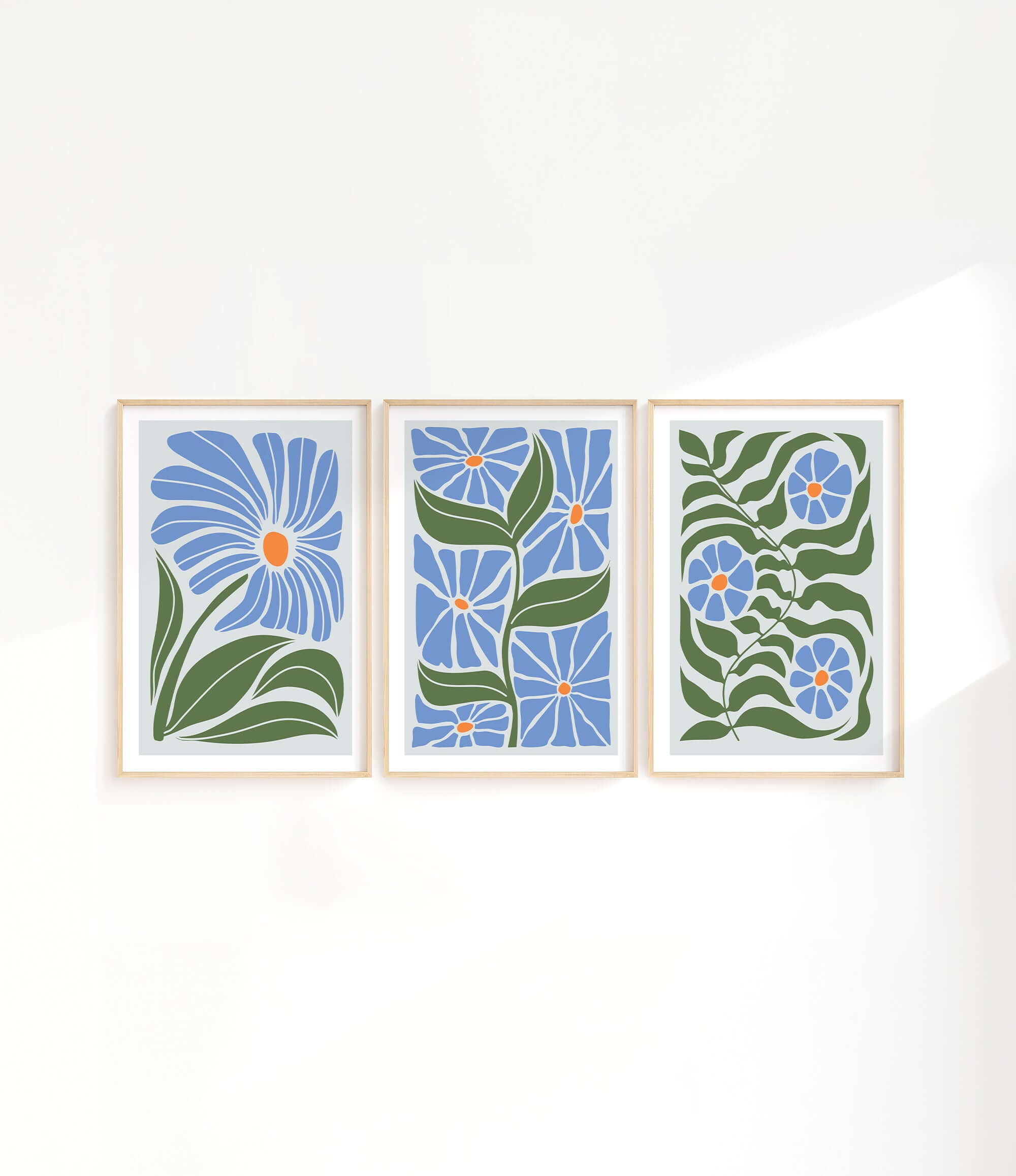 three paintings of blue flowers on a white wall