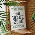 a sign that reads slow down no wake zone idle speed