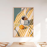 a wooden dining table with a bowl on it, and a framed illustration of a cup of coffee, a lemon slice, and a spoon on the table.
