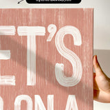 a person holding up a pink poster with white lettering
