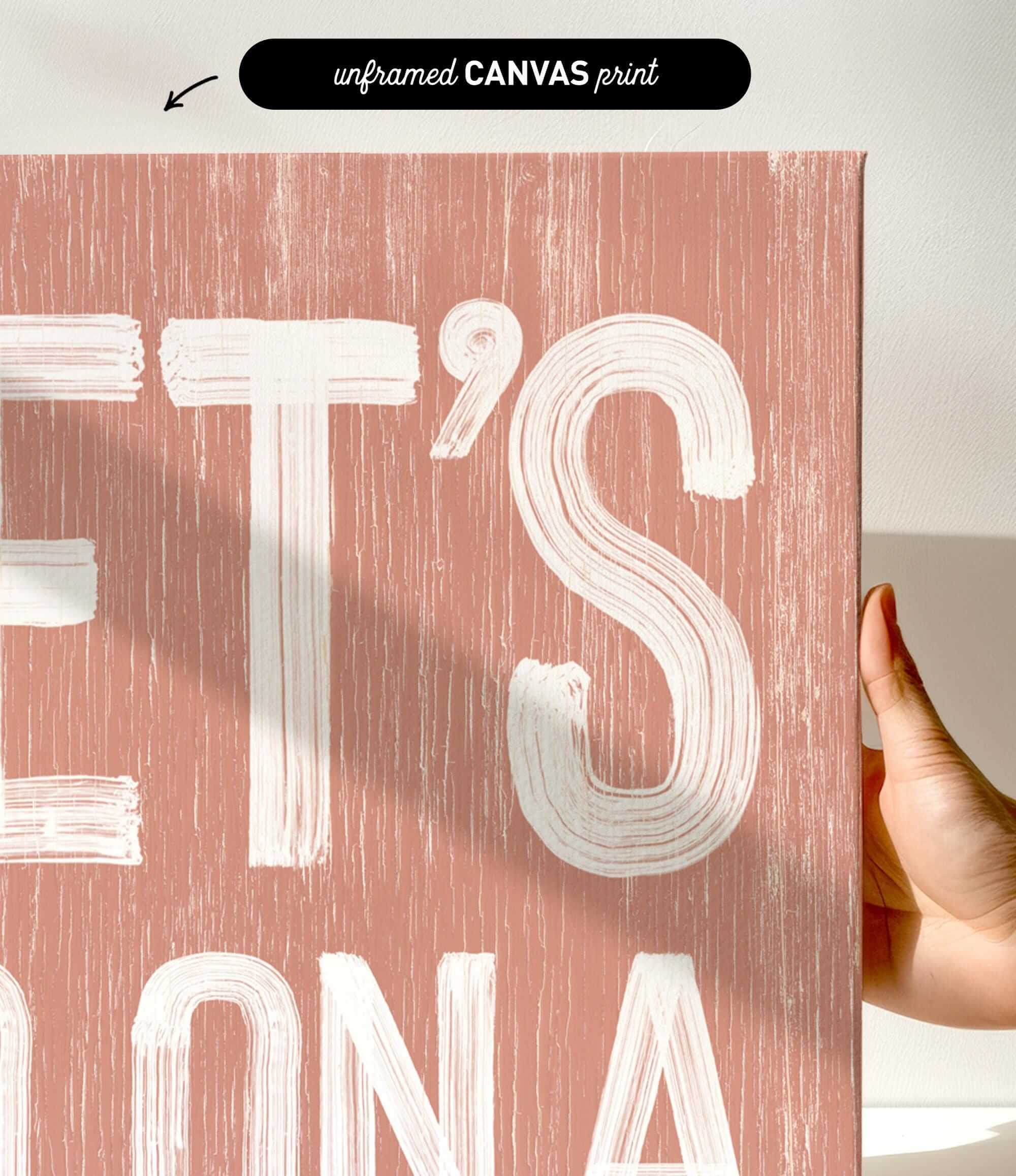 a person holding up a pink poster with white lettering