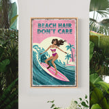 A framed poster with a woman surfing on a wave, surrounded by tropical plants.