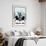 a bedroom with a bed, two lamps, and a framed poster of a mountain landscape with ski equipment.