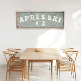 a dining room with a wooden table and four chairs. Above the table, there is a framed sign that says "APRESS SKI".