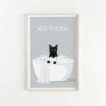 A framed poster with a black cat sitting in a white bathtub filled with bubbles, with the text "WASH YOUR PAWS" displayed above the cat.