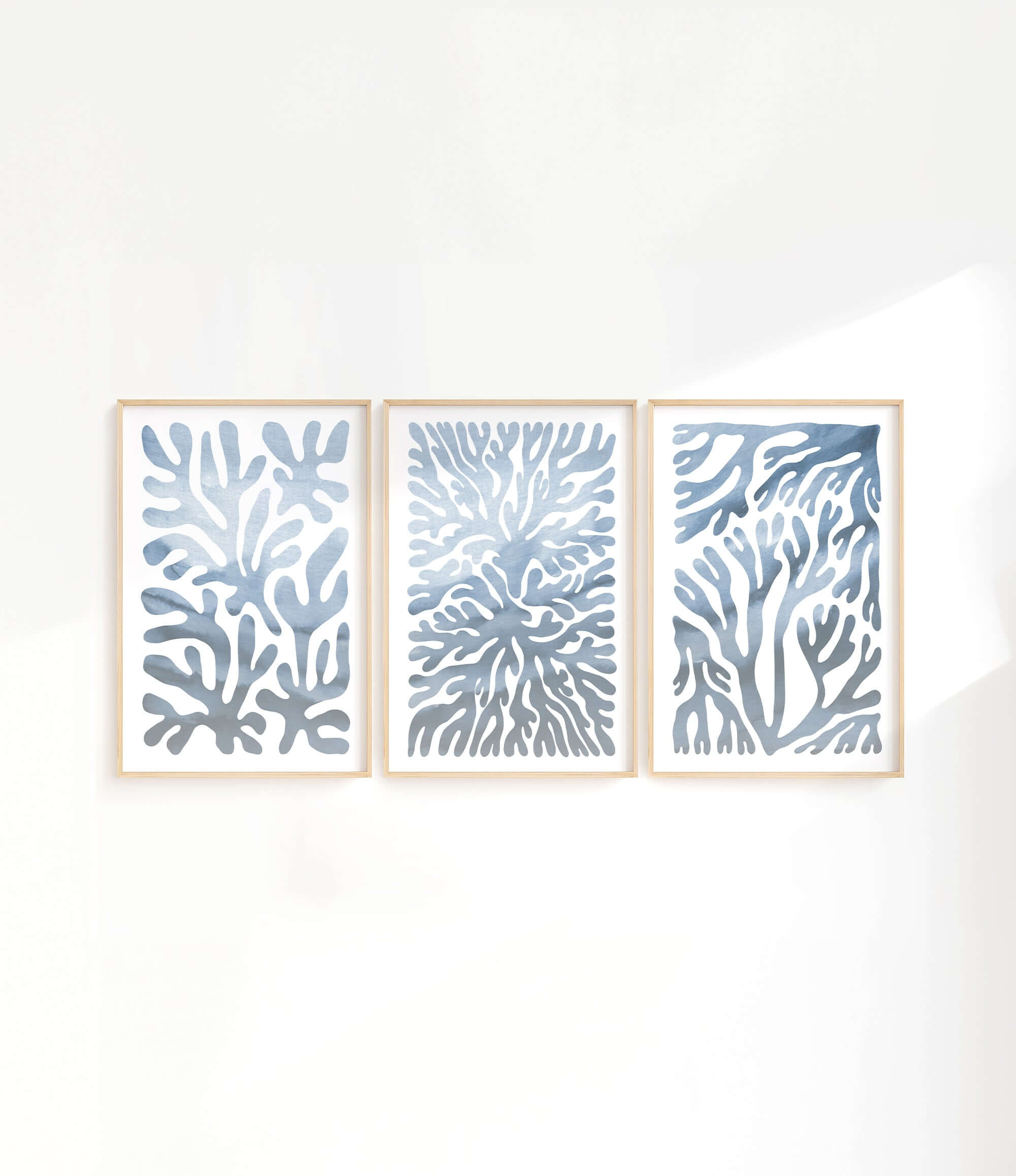 three paintings of blue corals on a white wall