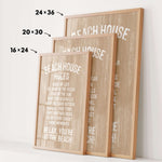 three framed beach house rules posters, each with a different size and orientation, displayed on a white wall.