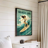 a framed vintage green poster of a woman surfing on a beach, with the text "BEACH LIFE" prominently displayed.