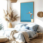 a serene and modern bedroom with a large bed, a potted plant, and a framed artwork of a woman diving into the water.