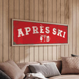 a cozy living room with a large red sign that reads "APRÈS SKI" hanging on the wall above a couch.
