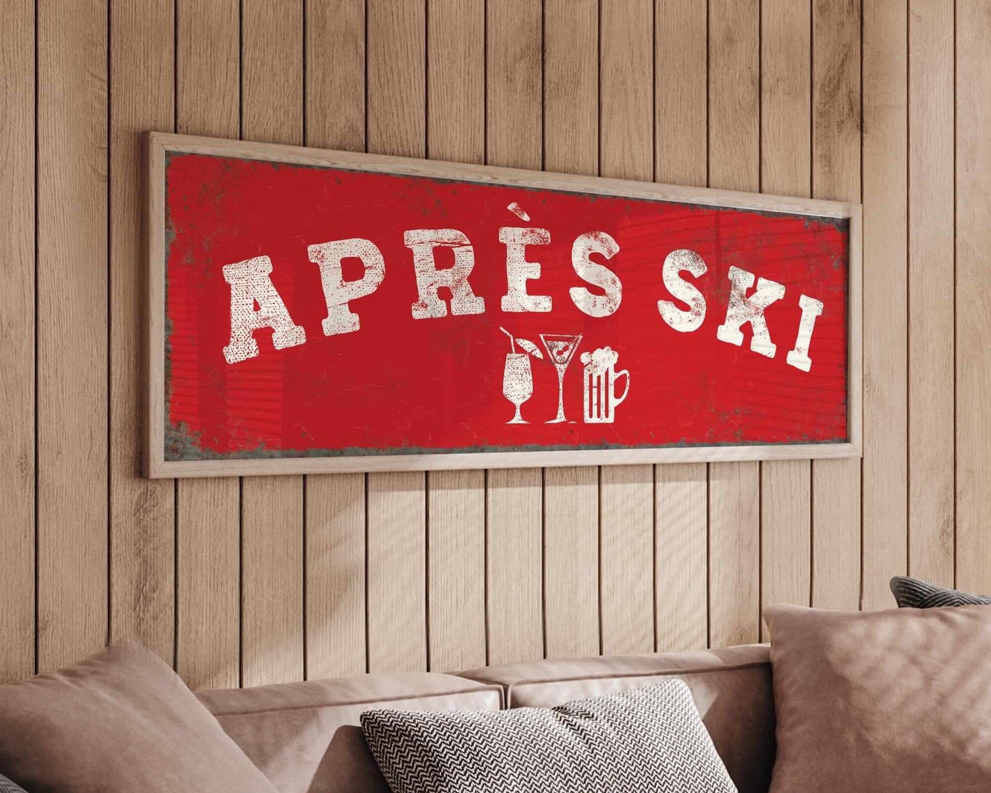 a cozy living room with a large red sign that reads "APRÈS SKI" hanging on the wall above a couch.