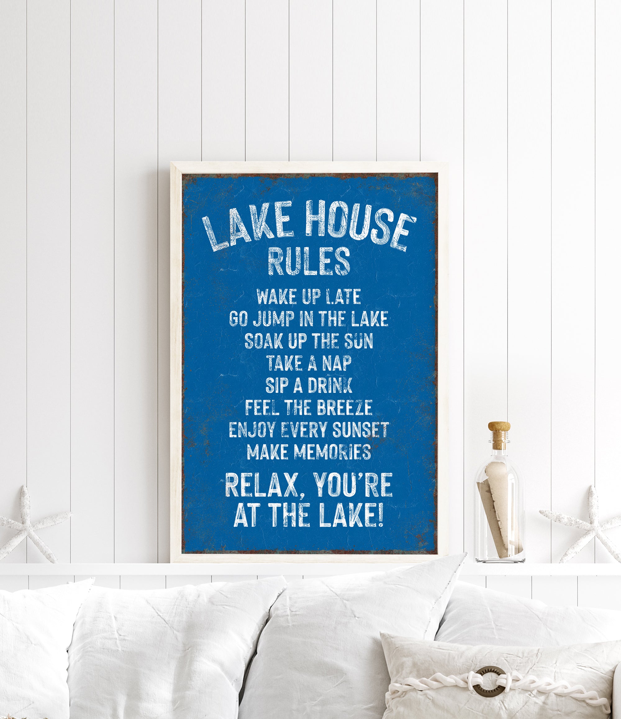 a framed sign with a list of rules for a lake house, including activities such as wakeboarding, swimming, and napping.