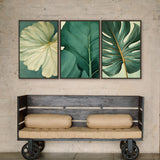 a wooden bench with two beige cushions, positioned in front of three framed botanical prints on a wall.
