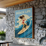 a framed "Beach Life" poster of a woman surfing on a wave, mounted on a stone wall.
