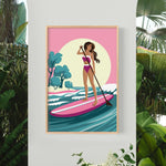 A woman in a pink swimsuit is paddleboarding on a pink surfboard, surrounded by tropical plants and a pink and yellow sunset in the background.