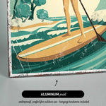 A woman is standing on a surfboard and paddling through the waves, with a beach and trees in the background.