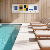 a serene outdoor setting with a swimming pool, wooden lounge chairs, and a wooden wall with a framed artwork depicting nautical symbols.