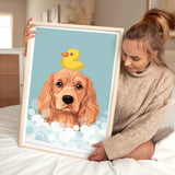 A woman is sitting on a bed holding a framed picture of a dog with a yellow rubber duck on its head.