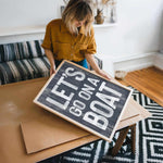 a woman holding a sign on top of a table