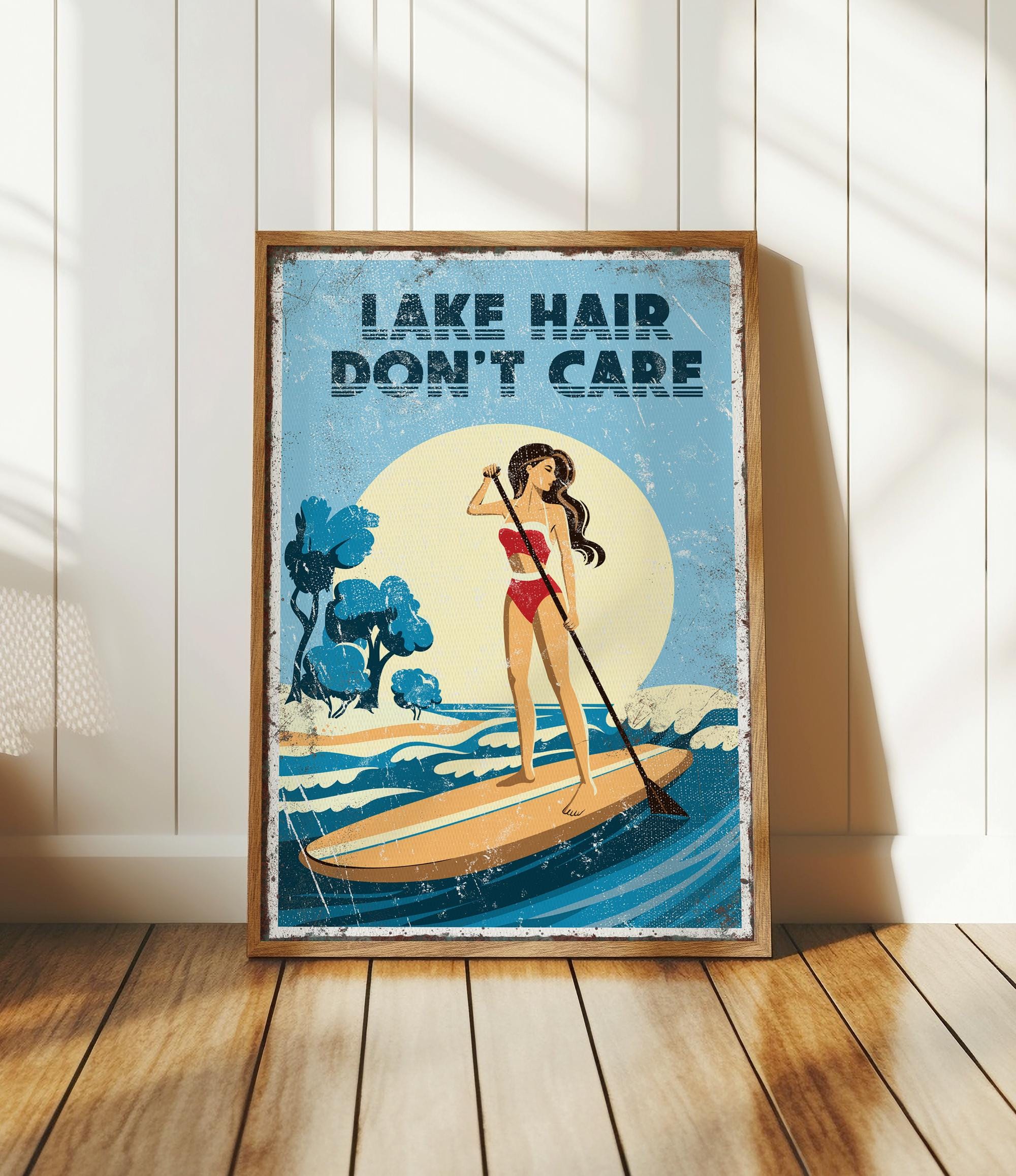 a woman paddleboarding on a lake, with the text "LAKESHORE DON'T CARE" displayed prominently.
