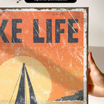 a person holding up a poster with a boat on it