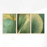 three framed artworks depicting various green leaf patterns, arranged in a row on a white wall.