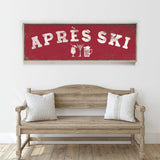 a wooden bench with two pillows, and above it is a red sign with the text "APRÈS SKI" in white letters.