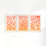 three orange and white paintings on a white wall