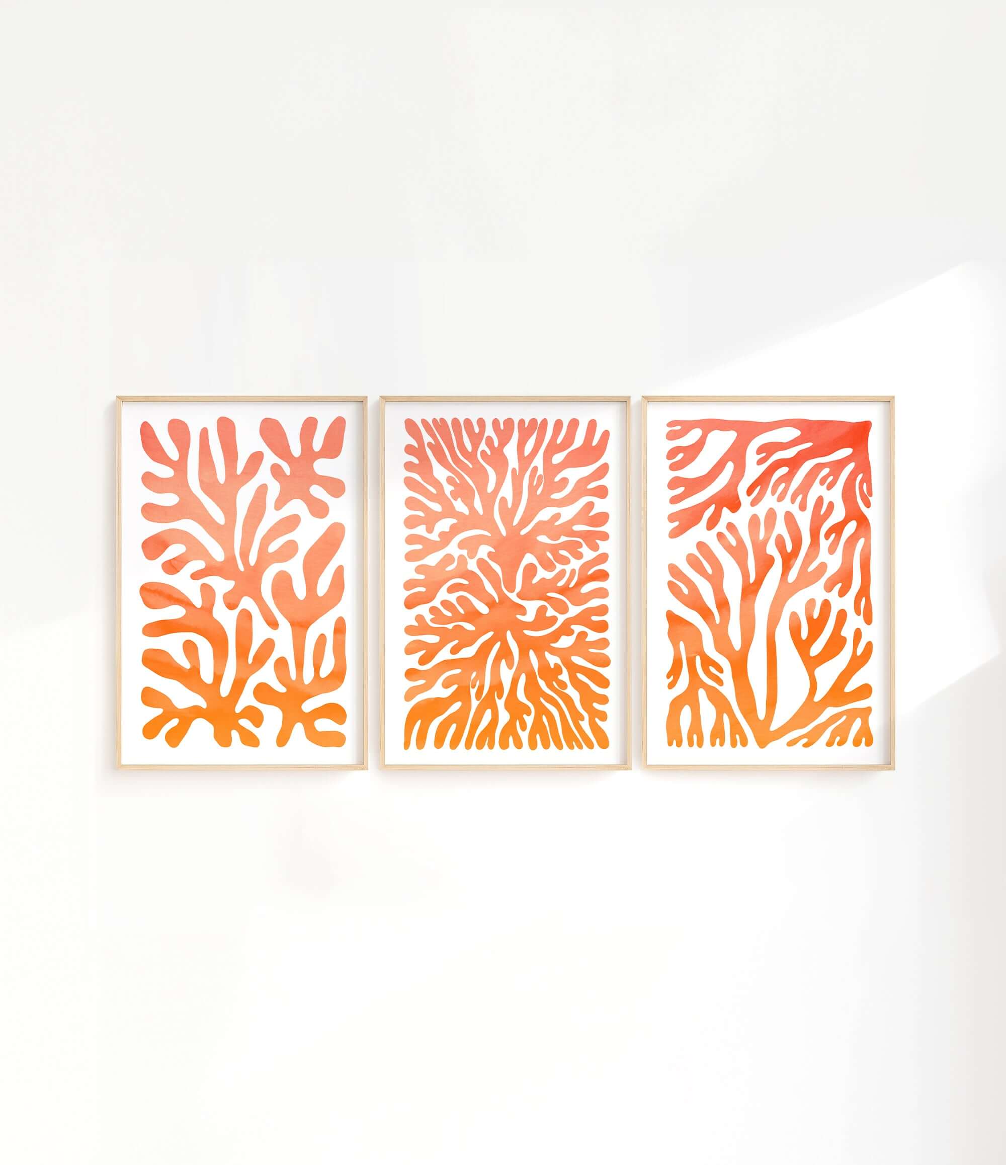 three orange and white paintings on a white wall