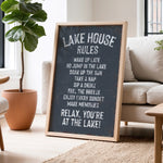 A chalkboard sign in a living room displaying the "Lake House Rules" for guests to follow.