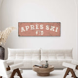 a living room with a white sofa, a wooden coffee table, and a decorative plant. Above the sofa, there is a large sign that says "APRES SKI".