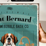 a hand holding a framed print with a dog illustration on it.