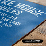 a close-up of a blue sign with white text, placed on a wooden surface.